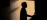 Practitioner silhouette in warm candlelit interior space